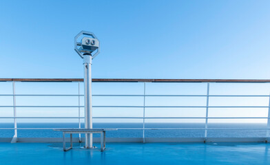 Obraz premium Jumelles sur le pont d'un navire de croisière en navigation en mer avec un ciel bleu sans nuage.