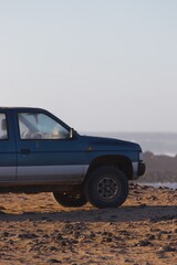 Fototapeta na wymiar Car parked on the edge of a cliff besides the sea 