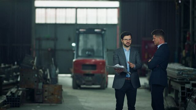 Concept of industrial development the Caucasian two men investor and main engineer discussing strategies and plan of work in the middle of production zon