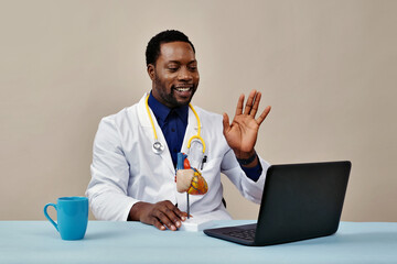 Doctor waving hand in online appointment.