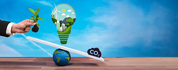 Businessman balance light bulb on scale with CO2 emission icon, demonstrate ESG commitment and...