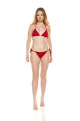 Fototapeta premium Full body, front view young blond woman in bikini posing on white background