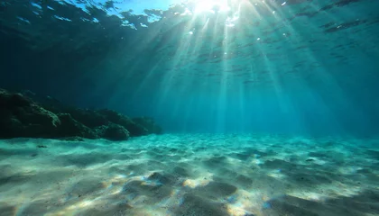 Fotobehang underwater background deep blue sea and beautiful light rays with sandy floor © Richard