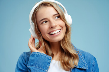 Portrait of smiling beautiful woman with silky hair hearing wireless headphones listening music...