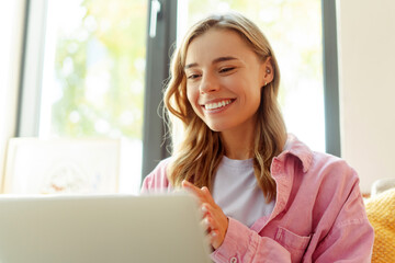 Smiling attractive woman using laptop computer communication online, having video call. Happy successful freelancer working from home