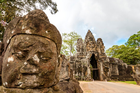 South gate of Angkor Thom along with a bridge of statues of gods and demons. Two rows of figures each carry the body of seven-headed naga. Angkor, Siem Reap province, Cambodia, Asia