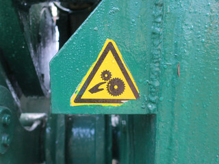warning sign sticked on a green painted part of a bridge