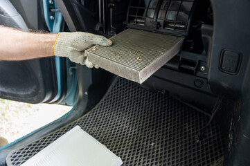 A mechanic changes the cabin air filter of a car.
