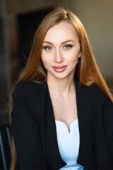 Fototapeta premium portrait of a Beautiful businesswoman with long red hair in black business suit.