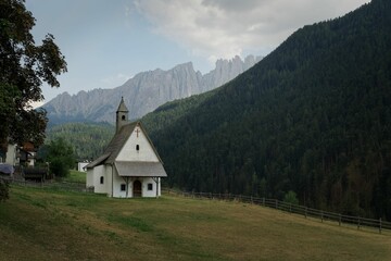 Fototapeta na wymiar Beautiful church located in the Italian Alps (Dolomites) surrounded by a large plain in summer.