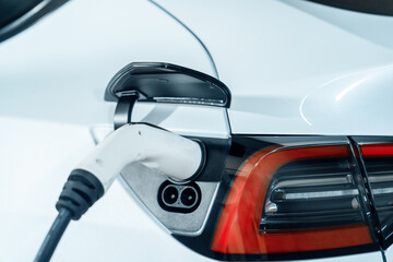 EV electric car recharge at shopping center parking lot charging in downtown city showing urban...