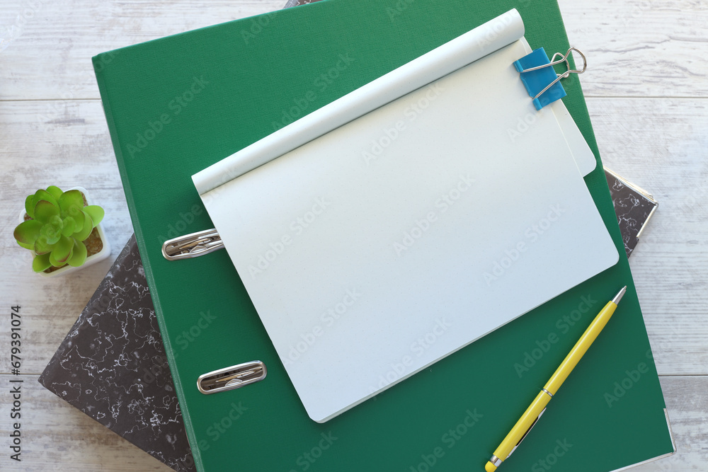 Poster stack of notepad folders. on a wooden table