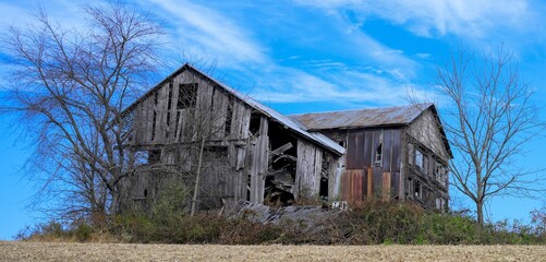 Aged wooden house stands alone in a desolate rural landscape