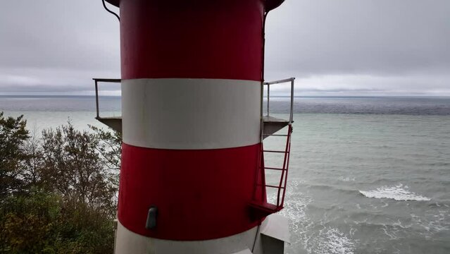 Video footage of a lighthouse serving as a beacon on the edge of the cliff in Møn, overlooking the sea. Lighthouse as cross-brand fire stand atop the cliff.