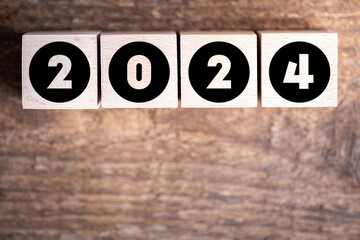 Happy new year 2024 background new year holidays card on wooden blocks. 2024 New year resolutions, goals. Wooden 2024 card