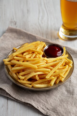 Homemade French Fries with Ketchup and Cold Beer, side view. Close-up.