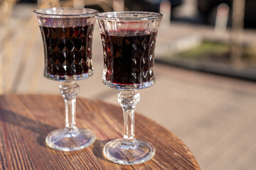close up of two glasses full of red wine on the table on the street, celebrate an occasion 