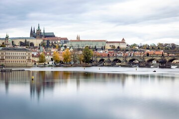 Fototapeta na wymiar Picturesque scene featuring a tranquil body of water with a bridge spanning its width in Prague