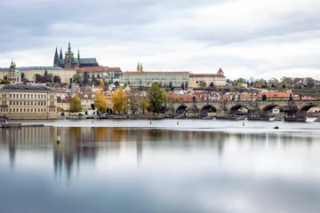  Picturesque scene featuring a tranquil body of water with a bridge spanning its width in Prague © Wirestock