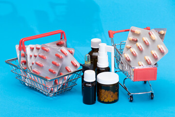 Buying Medicines. Drug Addiction Concept: Pills and Capsules in Shopping Cart on Blue Background. Global Pharmaceutical Industry and Big Pharma. Ordering Pharmaceutical Products