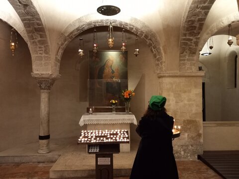 Fedeli in preghiera nella cripta della Basilica di San Nicola. Bari, Italia
