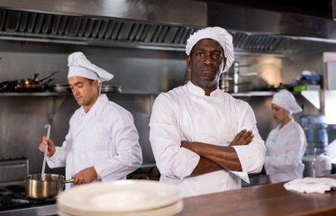 Self-confident chef manages team of chefs in the restaurant kitchen