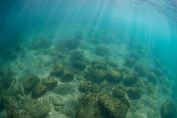 Rock and sand view underwater.