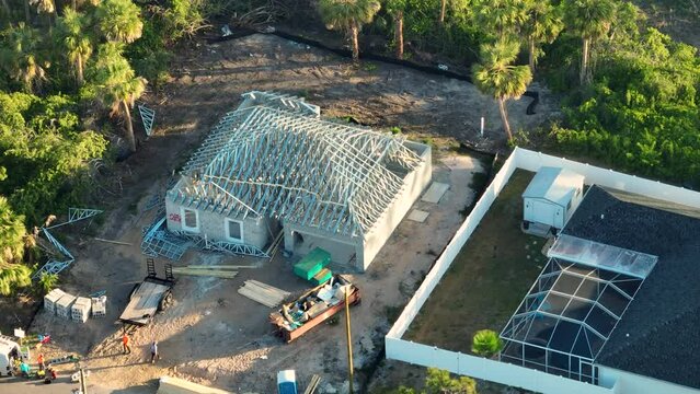 View from above of rooftop assembly made from steel truss framework on unfinished house under construction in Florida suburban area. Development of American housing concept
