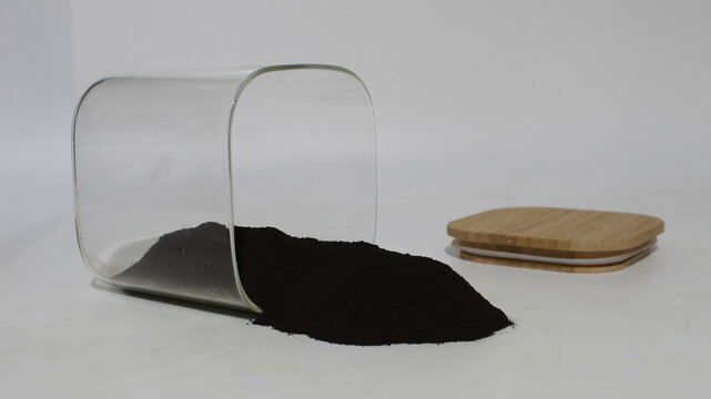 Black walnut hull powder spilled from a jar.