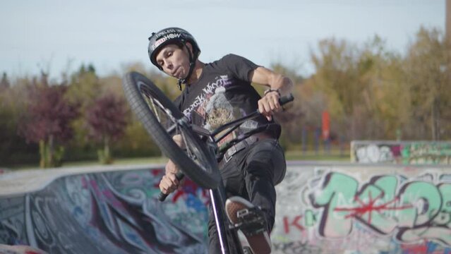 Bmx Rider jumps into air from half pipe and performs trick in super slow motion