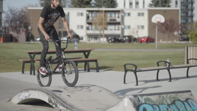 Bmx Rider jumps off of mini ramp and does trick in super slow motion