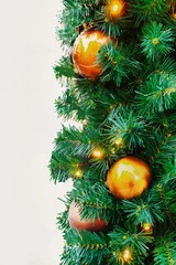 an isolated picture of pine christmas tree branches with orange decorations and lights