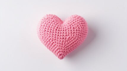 Fototapeta premium pink knitted heart on white background. Top view with copy space.