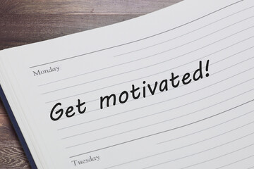 Get motivated concept diary reminder open on a desk