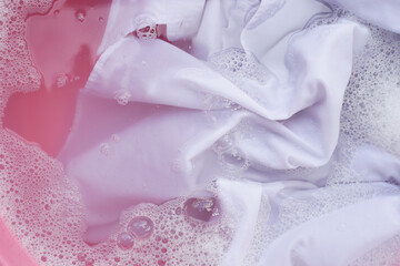 Laundry concept, white shirt soaking in water with detergent water dissolution, washing cloth
