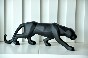 escultura pantera negra em painel ripado branco  © Alexandre