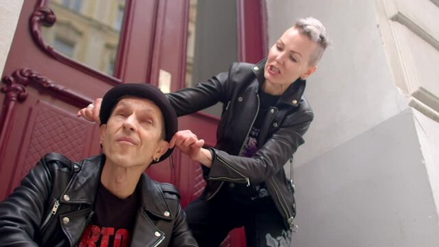 Adult couple preparing to shooting. Sense of togetherness and affection, reflecting the bond between the two individuals. People are clad in leather biker jackets, embodying the punk style. 