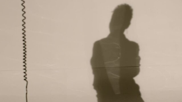 Shadows of people on a white background. Metaphor for hidden or implicit aspects of personality, identity, or relationships between individuals. Image of mystery and secrecy.