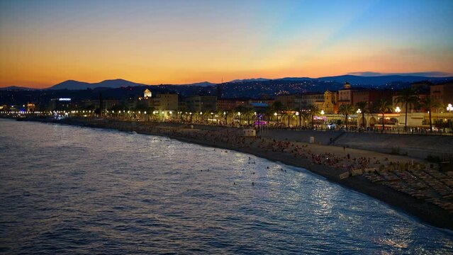Panoramic view of Nice, France from a view point at sunset. Promenade des Anglais with illumination, classic buildings, Mediterranean sea coast