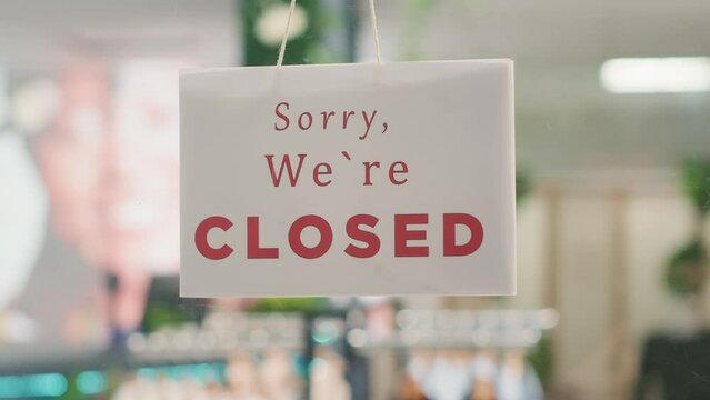 Extreme close up shot of message on fashion boutique door announcing customers that shop is closed. Sorry we are closed sign in empty eco friendly second hand clothing outlet