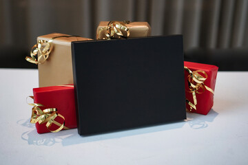 black voucher gift box as mockup template with red christmas presents or gifts around for black...