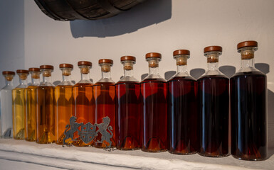 Different colours and ages of cognac spirits in bottles in distillery in Cognac white wine region,...