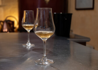 Tasting of cognac spirit aged in old French oak barrels in cellar in distillery in Cognac white wine region, Charente, Segonzac, Grand Champagne, France