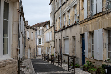 View on old streets and houses in Cognac white wine region, Charente, walking in town Cognac with...