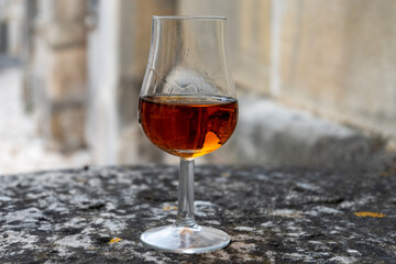 Tasting of cognac alcohol drink and view on old streets and houses in town Cognac, Grand Champagne, Charente, strong spirits distillation industry, France
