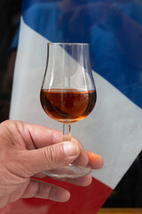 Tasting of cognac alcohol drink and view on French flag, town Cognac, Grand Champagne, Charente, strong spirits distillation industry, France