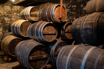 Aging process of cognac spirit in old French oak barrels in cellar in distillery in Cognac white wine region, Charente, Segonzac, Grand Champagne, France - obrazy, fototapety, plakaty