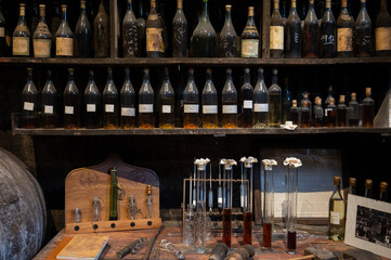 Blending process of cognac spirit and old French oak barrels in cellar in old distillery in Cognac...