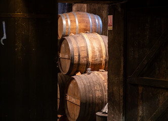 Aging process of cognac spirit in old French oak barrels in cellar in distillery in Cognac white...