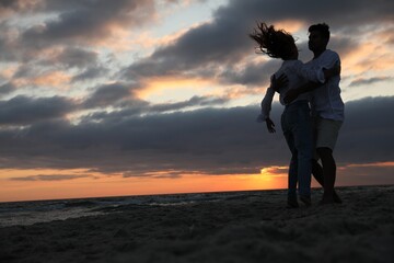 Fototapeta premium Happy couple dancing on beach at sunset